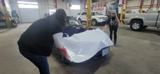 Two-person team installing color change wrap on Corvette — Blue Rose Wraps Springfield OR